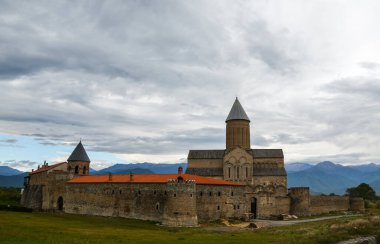 Kafkasya dağlarının eteklerinde bulutlu gökyüzüne karşı Aziz George Katedrali olan Alaetti Manastırı 'nın dışında. Kakheti bölgesi, Gürcistan