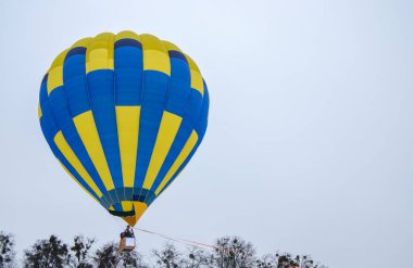 Havacılık festivali sırasında arka planda uçan çok renkli sıcak hava balonu. Seyahat ve hava taşımacılığı kavramı