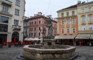Fountain with Amphitrite statue on Rynok Square (Market Square) of old town in Lviv, Ukraine. View from the back.