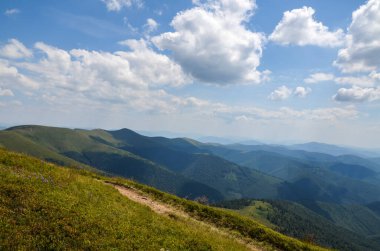 Tepelerde yeşil çayır ve orman olan yaz dağı manzarası mavi gökyüzünün altında bulutlarla. Borzhava Karpatların, Ukrayna 'nın harika seyahat yeri
