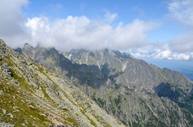 Gri kayalık dağ sırasının keskin zirveleri her yıl bulutlarla kaplı yeşil bir gökyüzünün altında bitki örtüsüyle kaplıdır. Yüksek Tatra Dağları, Slovakya