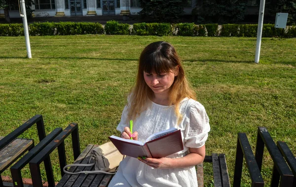 Smiling Girl White Dress Writing Something Her Notebook Park Freelance — Stockfoto