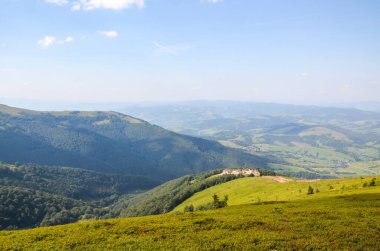Descent from the Borzhava mountain range with a picturesque view of the valley and the village of Pylypets. Carpathians, Ukraine