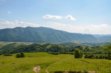 Summer mountain landscape with green rolling hills and the village in the valley in to the distance. Kolochava Transcarpathia, Carpathian Mountains, Ukraine 