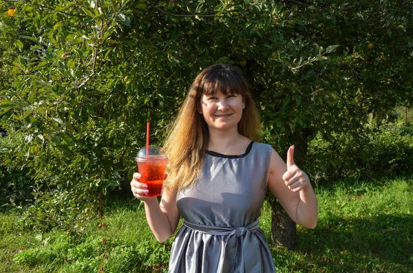 Young smiling girl holding tasty sweet fresh lemonade with ice, amazing relaxing day, tasty drink, outdoor