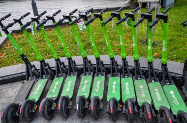 Row of city Electric Scooters parked on the street for rent. Eco transport concept for every day