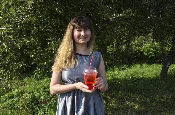 Young smiling girl holding tasty sweet fresh lemonade with ice, amazing relaxing day, tasty drink, outdoor