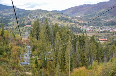 Renkli ağaçlarla dolu bir dağ yamacında boş bir saç kaldırma. Sonbahar sezonunda asansör. Karpat Dağları, Ukrayna