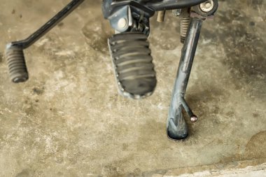 Ahırı kullanan süper motorsiklet ayaklı kapsül yolda park ederken motoru kullanıyor. Araç gereç parçası parçası. Yakın çekim ve seçici odak.