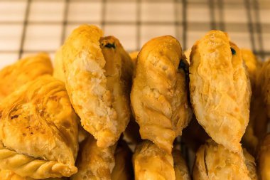 Körili börek, doldurulmuş tavuk ve fasulye, çay fincanıyla çifti yer.