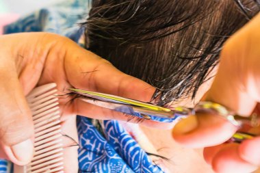 Bangkok, Tayland - 14 Kasım 2021: Bangkok, Tayland 'da kadın saç kesme makası kesen kuaföre yakın çekim.