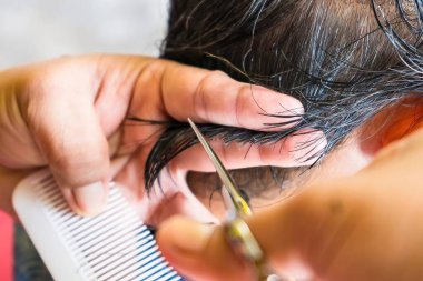 Bangkok, Tayland - 14 Kasım 2021: Bangkok, Tayland 'da kadın saç kesme makası kesen kuaföre yakın çekim.