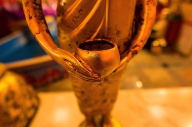 Buda heykeli bağış kasesi taşıyor.