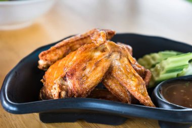 Kızarmış tavuk kanatları ve yeşil sebze yaprakları. Tayland yemeğinin seçici odak noktası..