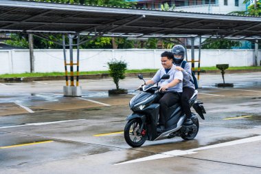 Bangkok, Tayland - 25 Eylül 2021: Bangkok, Tayland 'da yağmurda motosiklete binen kimliği belirsiz bir adamın görüntüsü bulanıklaştı.