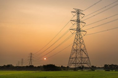 Yüksek voltaj direği, yüksek voltaj kulesi gökyüzü gün doğumu arka planı.