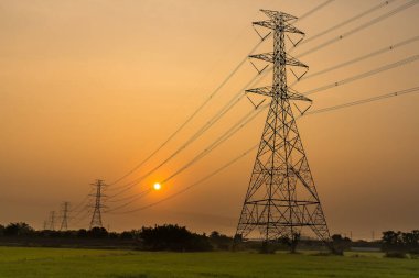 Yüksek voltaj direği, yüksek voltaj kulesi gökyüzü gün doğumu arka planı.