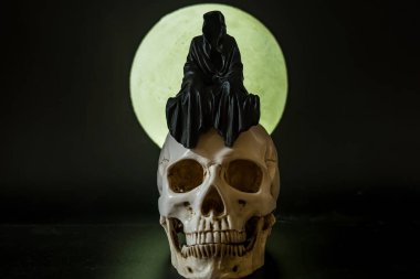 Dolunayda bir kafatasında oturan Azrail heykeli..