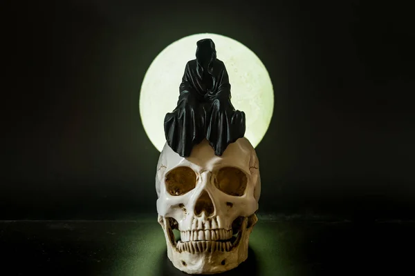 Posąg Ponurego Żniwiarza Siedzącego Czaszce Podczas Pełni Księżyca Tło — Zdjęcie stockowe