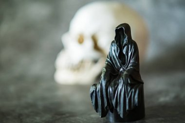 Azrail heykeli oturuyor ve kafatası arka planda..