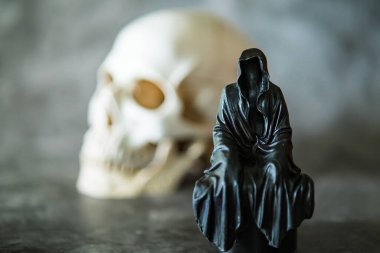 Azrail heykeli oturuyor ve kafatası arka planda..