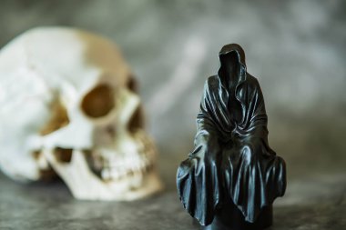 Azrail heykeli oturuyor ve kafatası arka planda..