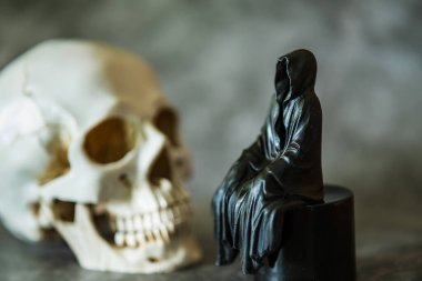 Azrail heykeli oturuyor ve kafatası arka planda..