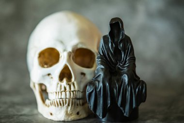 Azrail heykeli oturuyor ve kafatası arka planda..