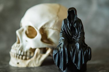 Azrail heykeli oturuyor ve kafatası arka planda..