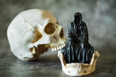 Azrail heykeli oturuyor ve kafatası arka planda..