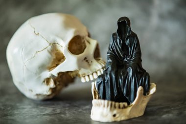 Azrail heykeli oturuyor ve kafatası arka planda..