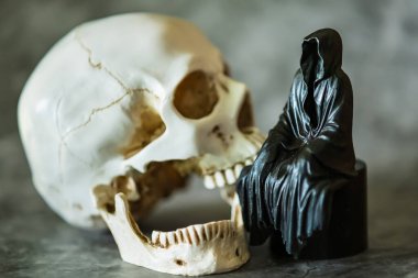 Azrail heykeli oturuyor ve kafatası arka planda..