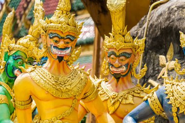 Nakhon Nayok, Tayland - 24 Nisan 2022: Tayland Nakhon Nayok, Tayland 'daki Maniwong Tapınağı' nda üç başlı yılanla savaşan melek ve şeytanların altın heykeli.