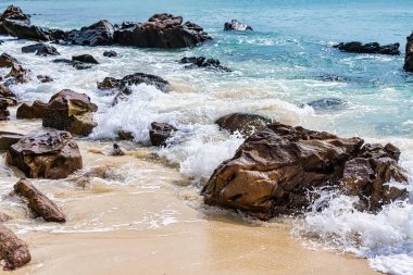 Sahilde kaya taşlı su sıçrama dalgalarının güzel arkaplanı.