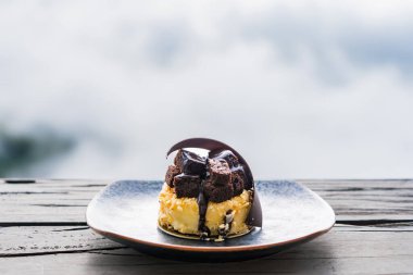 Arkadaki ahşap masaya yerleştirilmiş nefis siyah çikolatalı pasta. Güzel manzara..