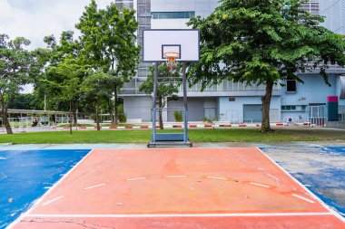 A view of a basketball hoop and background at an outdoor park.