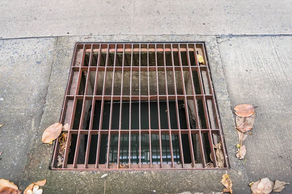 Old iron grates with rust through a long time. Used to drain concrete surface to prevent water outflow and prevent flooding within residential areas.