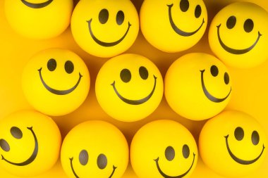 Happy faces ball on yellow background, smiling background.