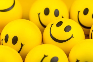 Happy faces ball on yellow background, smiling background.