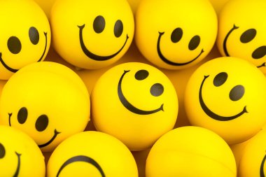 Happy faces ball on yellow background, smiling background.