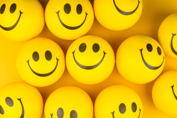 Happy faces ball on yellow background, smiling background.