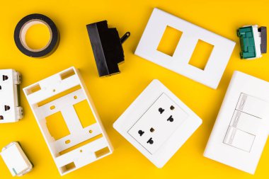 Sarı arka planda farklı elektrikçi malzemeleri var. Metin için alanı olan profesyonel elektrikçi araçlarının arkaplanı. Elektrikçi konsepti ev elektrik tamircisi.