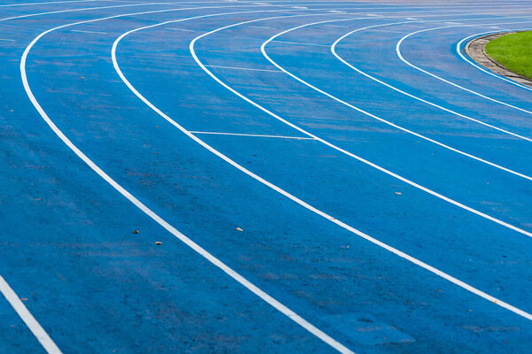 фон синей дорожки для соревнований по бегу на стадионе, фокус в центре.