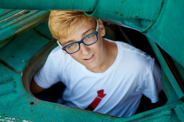 十几岁的男孩喜欢在一个旧水箱里戴眼镜 — 图库照片