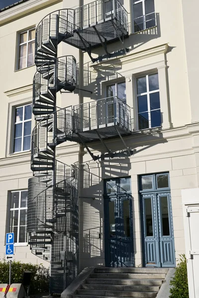 Metal circular staircase near residential building outside