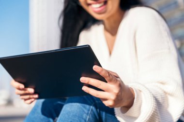 Dışarıda tablet kullanan tanınmayan genç bir kadın. Tablete odaklan.