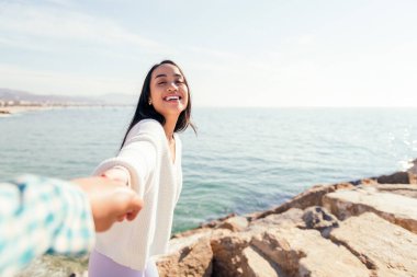 Aşk ve romantizm kavramının el ele tutuşan gülümseyen Asyalı genç kadın.