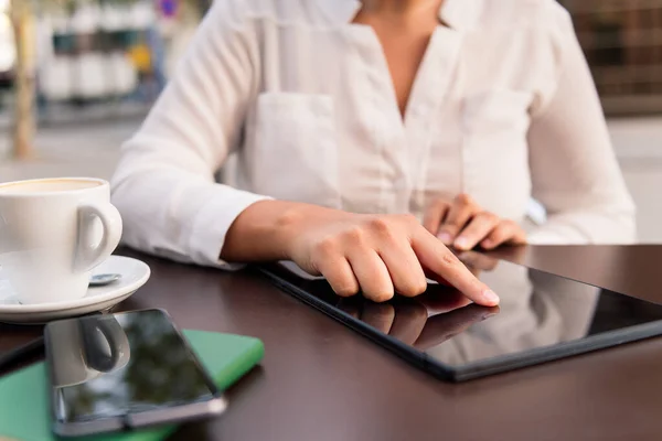 stock image hand of a woman using a digital tablet on the terrace of a coffee shop, concept of digital entrepreneur and urban lifestyle