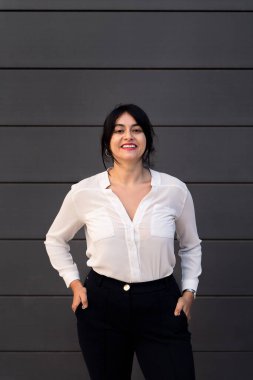 Gülümseyen iş kadını elleri ceplerinde kameraya bakıyor, başarılı girişimci ve şehir yaşam tarzı kavramı, metin için kopyalama alanı