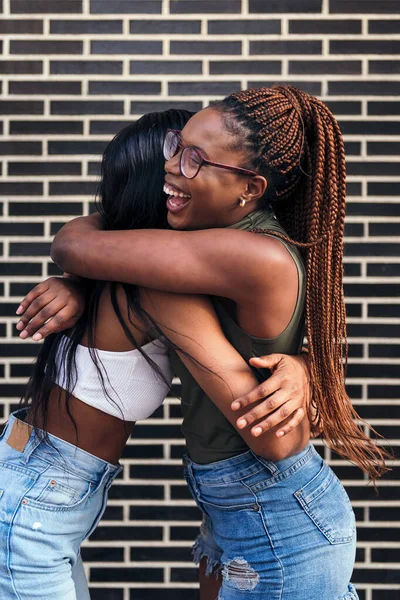 Pár Mladých Černošek Směje Objímají Šťastně Před Cihlovou Zdí Koncept — Stock fotografie
